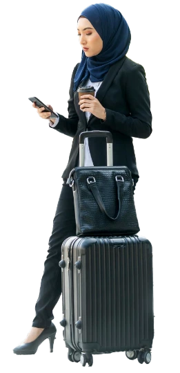Travel booker arranging a trip on her phone beside a cabin bag